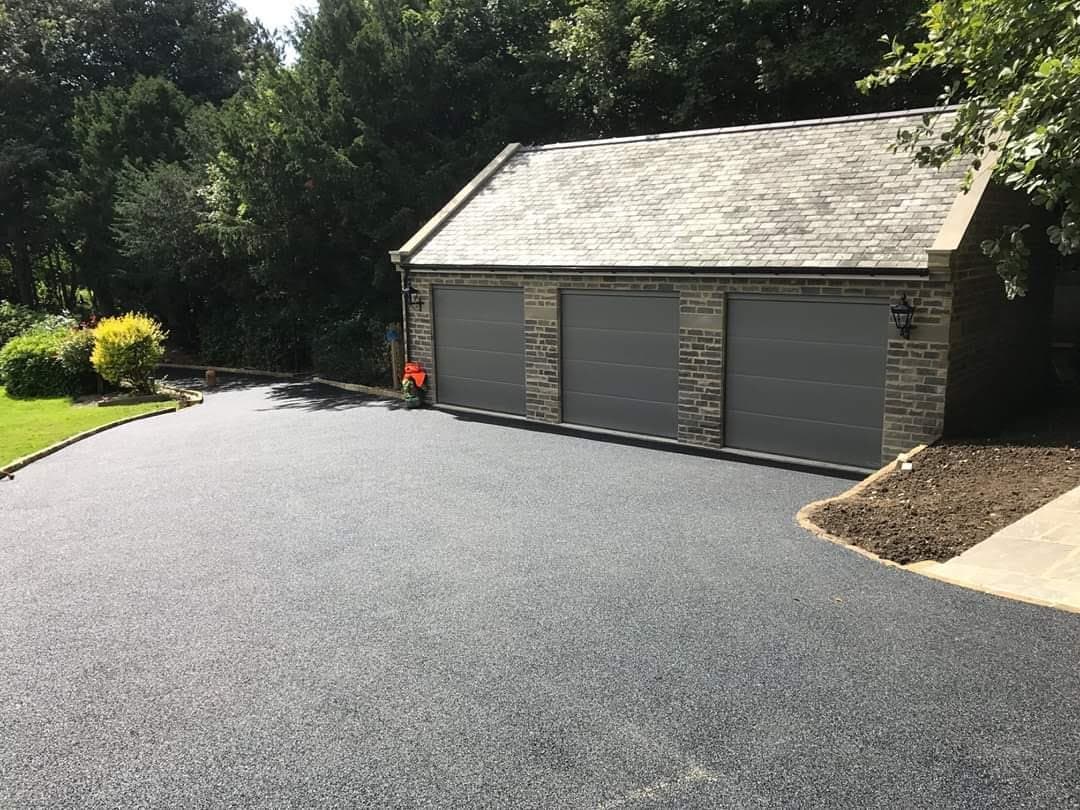 The stone garage with its three sectional doors and the newly laid driveway